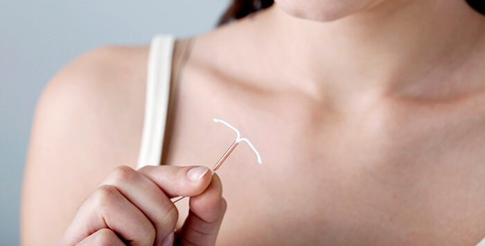 stérilet tenu en main par une femme