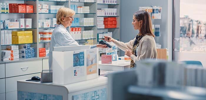 femme reglant un achat au comptoir d'une pharmacie