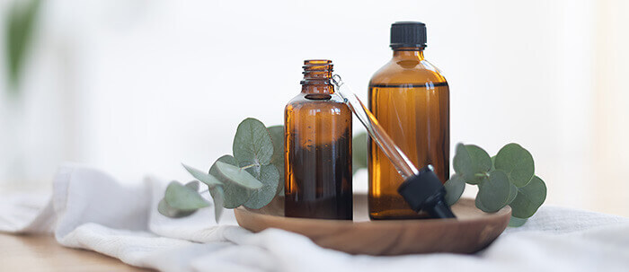 flacon d'huile essentielle d'eucalyptus entouré de feuilles d'eucalyptus