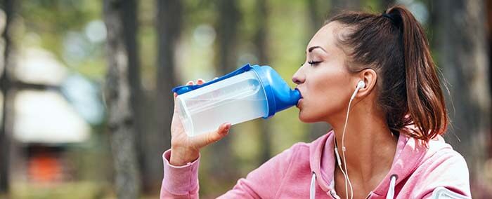 femme qui boit de l'eau dans une gourde