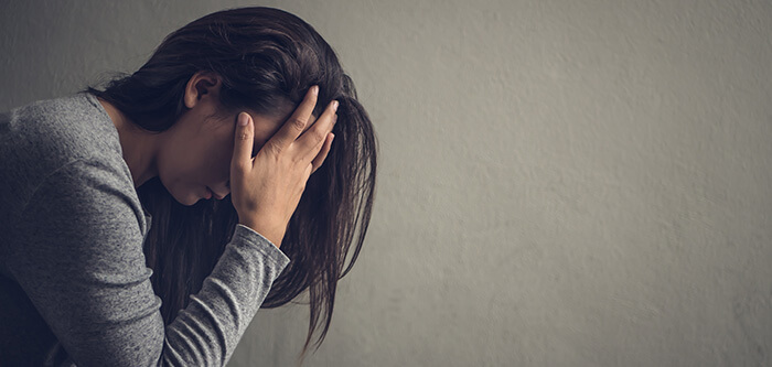 femme déprimée se tenant la tête dans les mains