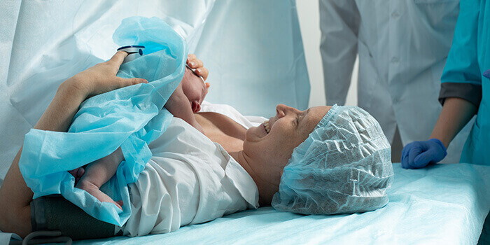 femme tenant son bébé dans les bras à l'issu d'une césarienne