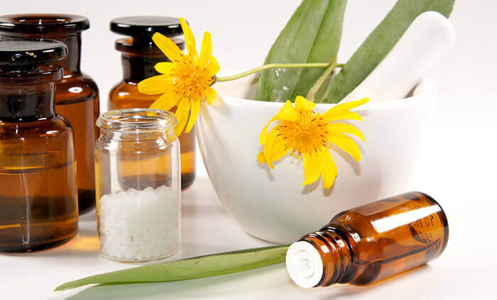 fleurs d'arnica accompagnées de granules homéopathiques à base d'arnica