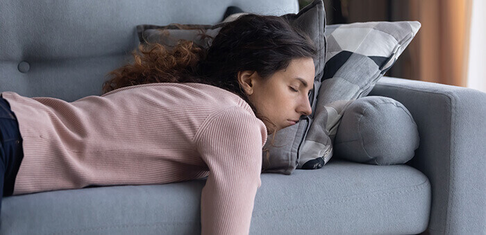 femme épuisée dormant sur un canapé