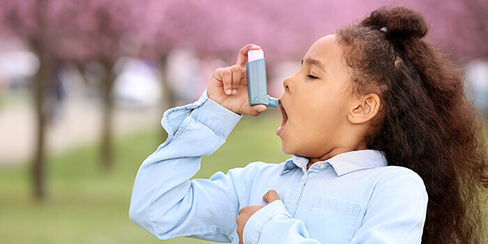 Petite fille utilisant un bronchodilatateur en cas de crise d'asthme