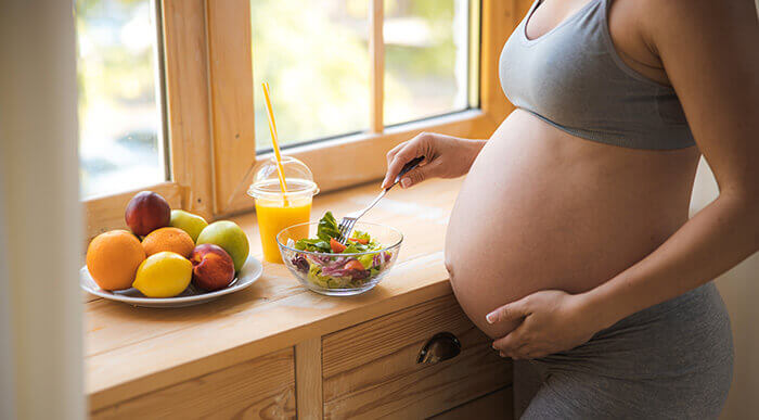 femme enceinte se préparant un repas sain dans sa cuisine