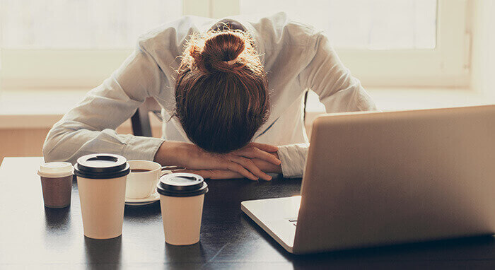 femme fatiguée avachie sur son bureau