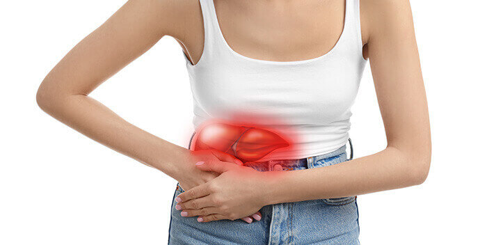 femme se tenant le ventre à cause d'une douleur au foie