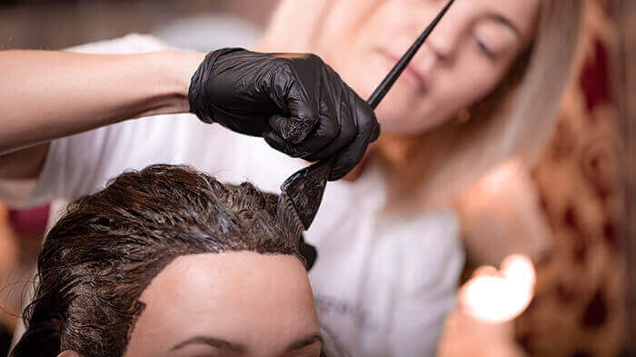 femme se faisant teindre les cheveux chez le coiffeur