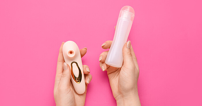 flacon de lubrifiant intime présenté à côté d'un sextoy