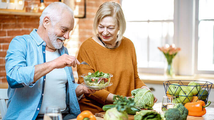 couple de senior préparant un repas équilibré dans leur cuisine
