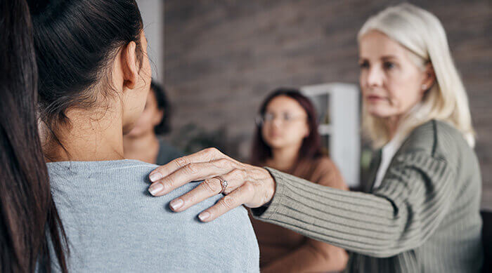 femme soutenant une autre femme dans le cadre d'un groupe de parole