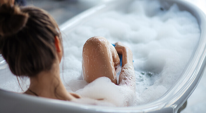 femme se délassant dans un bain moussant