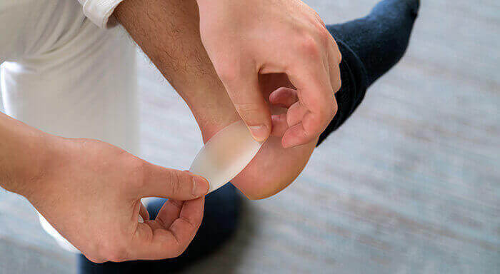 application d'un pansement sur une ampouel au niveau du pied