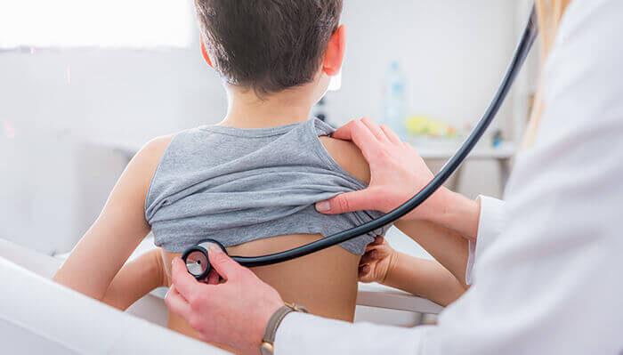 jeune garçon atteint d'une bronchite en consultation chez le médecin