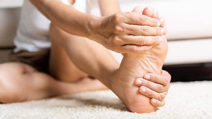 plan sur le pied d'une femme se massant pour soulager une crampe musculaire