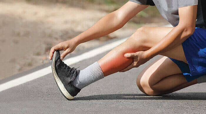 plan sur la jambe d'un sportif souffrant d'une crampe musculaire