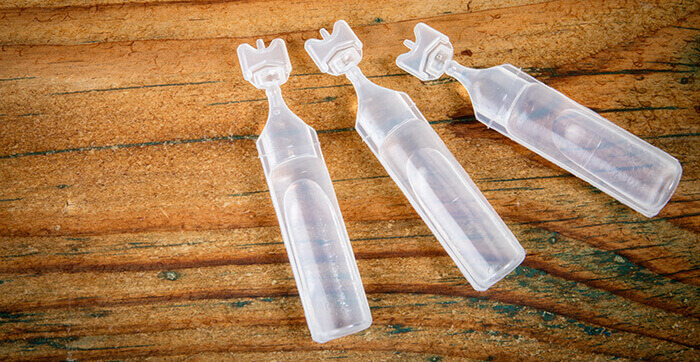 3 pipettes de sérum physiologique sur une fond boisé