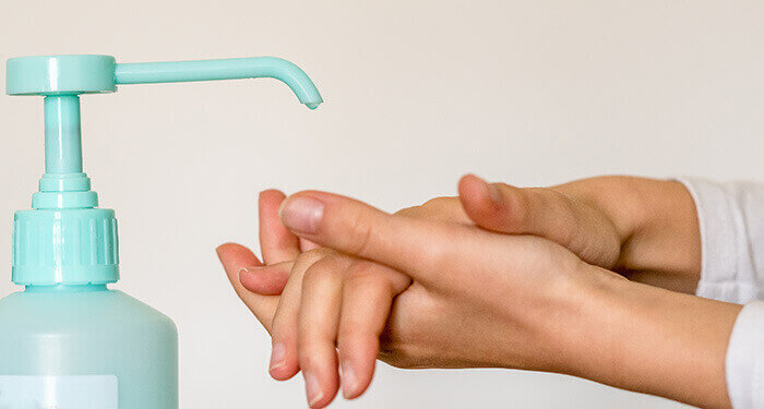 personne se frottant les mains avec du gel hydroalcoolique