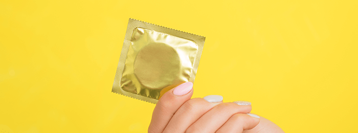préservatif masculin dans sa pochette sur fond jaune