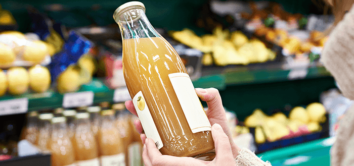 gros plan sur une bouteille de jus de fruit en verre dans un magasin