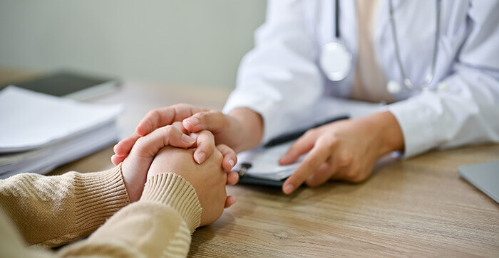 plan sur les mains d'un médecin tenant la main d'une patiente en guise de soutien