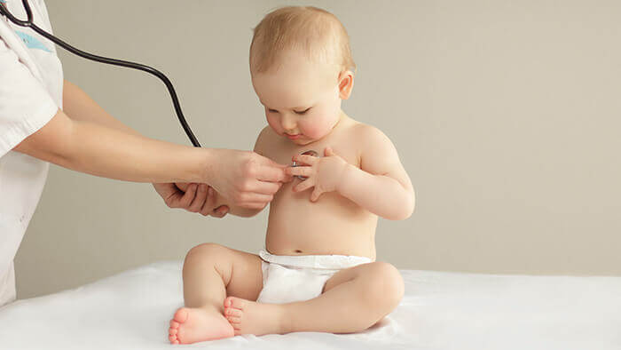 bébé en couche à qui l'on écoute le rythme cardiaque