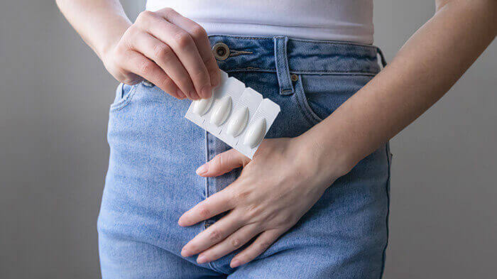 ovule antifongique tenue dans la main d'une femme portant l'autre main sur son intimité en signe d'affection