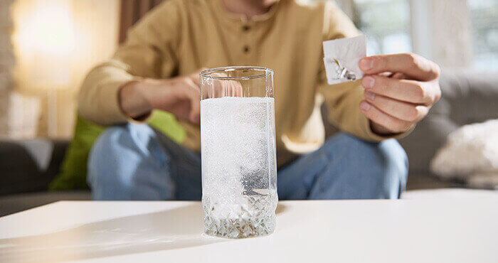 Comprimé d'Efferalgan effervescent se dissolvant dans un verre d'eau