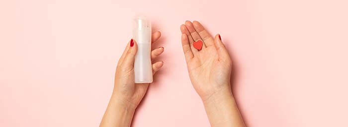 flacon de lubrifiant avec un petit coeur sur fond rose