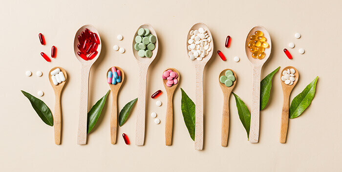 compléments alimentaires anti-oxydants présentés dans des cuillères en bois