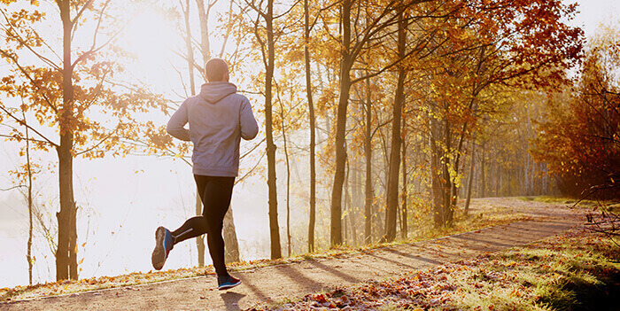 homme pratiquant un footing sur un chemin en automne