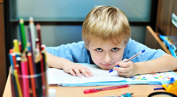 petit garçon gaucher tenant un stylo à l'école