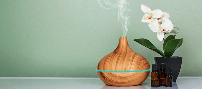 diffuseur d'huiles essentielles avec une orchidée sur fond bleu