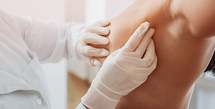 plan sur la palpation du sein d'une patiente par un médecin dans le cadre du dépistage du cancer du sein