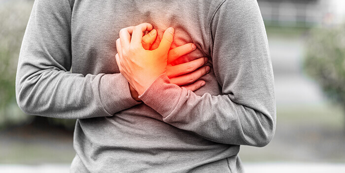 homme se tenant la poitrine de douleur
