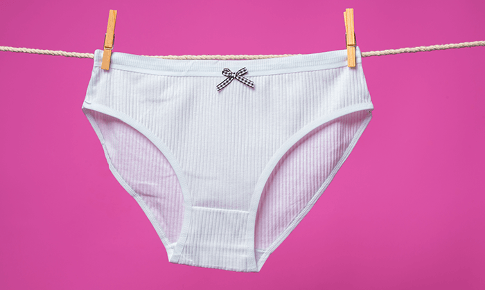 culotte blanche en coton accrochée à un fil avec des pinces à linge