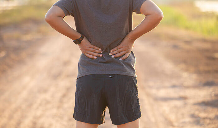 personne qui se tient le dos