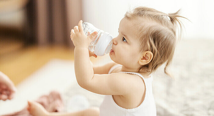 bébé qui boit de l'eau au biberon