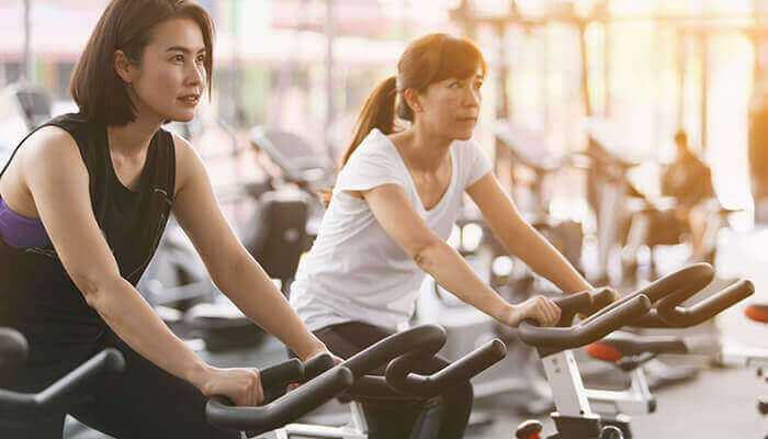 Deux femmes pratiquant le vélo d'intérieur dans une salle de sport