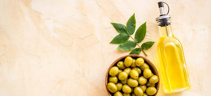 bouteille d'huile d'olive et bol d'olives vertes