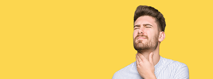 homme ayant mal à la gorge sur fond orange