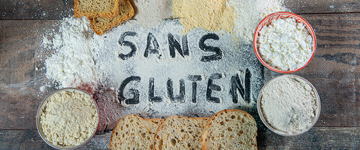 "Sans gluten" inscrit dans de la farine entourée de pains et céréales sans gluten
