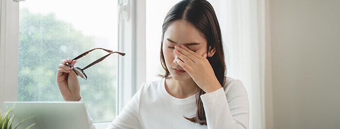 femme ayant les yeux irrités après avoir regardé un écran d'ordinateur