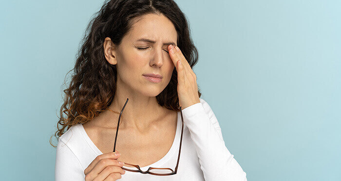 femme se frottant les yeux irrités