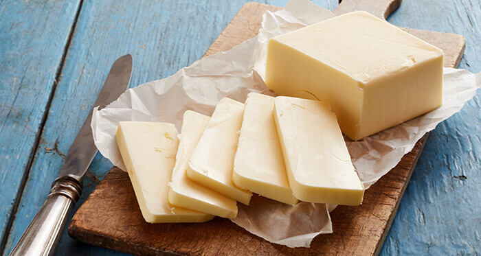 motte de beurre coupée en tranches sur une planchette de bois
