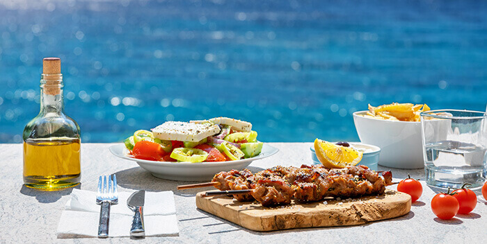 salades et plats typiques avec la mer en fond