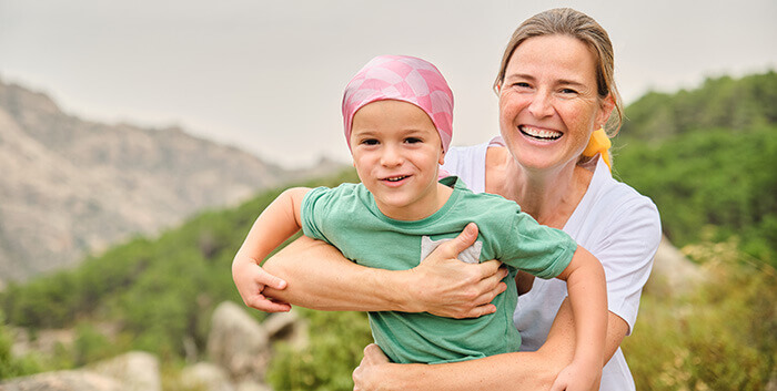 enfant atteint d'un cancer dans les bras de sa maman
