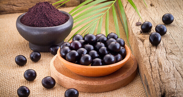 baies d'acai dans une coupelle accompagnées de poudre de baies d'acai