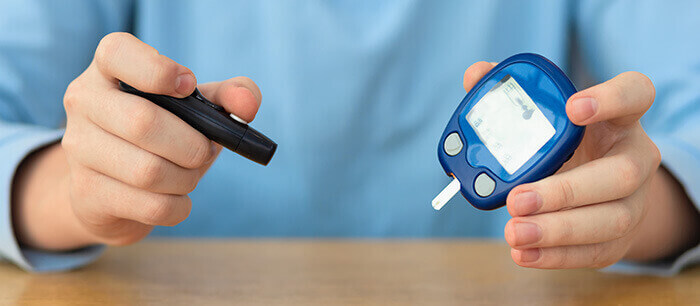 gros plan sur les mains d'un enfant qui tient un lecteur de glycémie